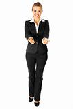 Full length portrait of smiling  business woman presenting something on empty hands
