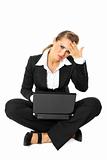 Sitting on  floor modern business woman with headache working on laptop
