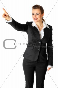 Full length portrait of smiling modern business woman  touching abstract screen
