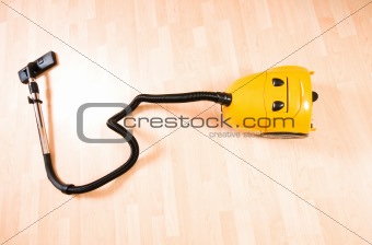 Vacuum cleaner on the polished wooden floor 