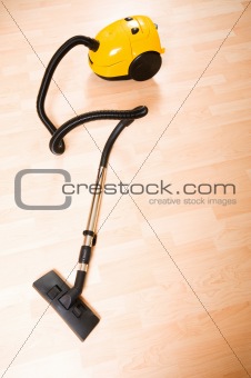 Vacuum cleaner on the polished wooden floor 