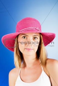 Young girl with beach hat against gradient background