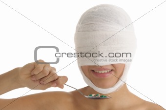 Woman with bandaged head with tablets on spoon
