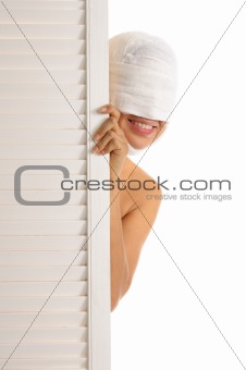 Young woman looks out because of door