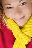 Smiling woman wearing red autumn or winter jacket and yellow scarf.