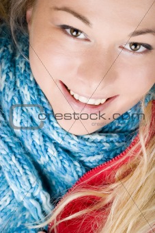 Smiling woman wearing red jacket and blue scarf. Autumn fashion.