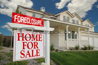 Foreclosure Sign and House with dramatic sky background.