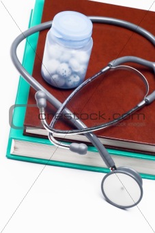 Stethoscope and pills on a medical book