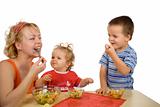 Mother and children eating fruit salad