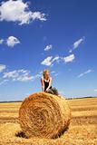 Woman sitting on a hay bale