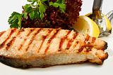 Grilled salmon steak with salad and lemon