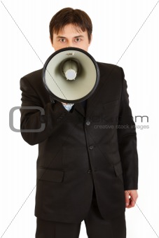 Serious modern businessman speaking into megaphone
