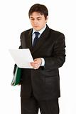 Serious modern businessman with folder in hand exploring document

