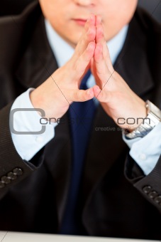 Businessman sitting at desk. Close-up on hands
