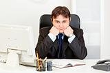 Businessman sitting at office desk and keep head on hands
