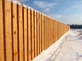 Wooden fence in the winter, amid the beautiful sky 