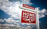 Red Foreclosure Home For Sale Real Estate Sign Over Beautiful Clouds and Blue Sky.