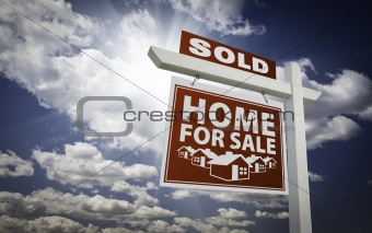 Red Sold Home For Sale Real Estate Sign Over Beautiful Clouds and Blue Sky.