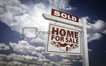 White Sold Home for Sale Real Estate Sign Over Beautiful Clouds and Blue Sky.