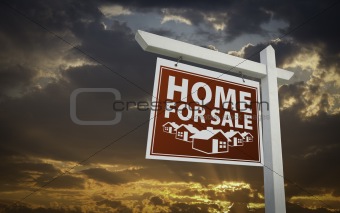 Red Home For Sale Real Estate Sign Over Beautiful Clouds and Sunset Sky.