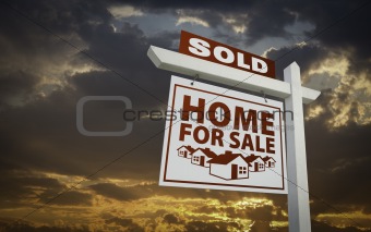 White Sold Home For Sale Real Estate Sign Over Beautiful Clouds and Sunset Sky.