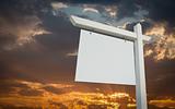 Blank White Real Estate Sign Over Sunset Sky Ready For Your Own Message.