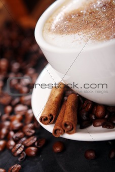 Coffee cup on the table with coffee beans around