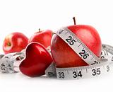 Red apples,heart and measuring tape on white