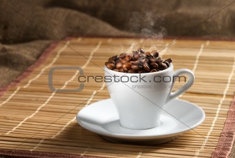 Coffee cup full of coffee beans