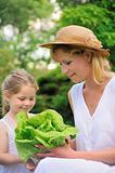 Young mother and daughter with lettuce