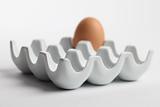Ceramic egg holder with brown chicken egg