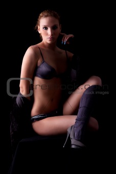 Beautiful and sexy blond woman sitting, wearing  lingerie, isolated on black, studio shot;
