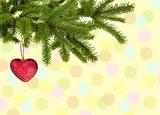 Christmas green branch with red heart over yellow background