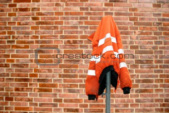 Construction site protection jacket in front of a brick wall