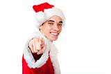 Smiling male teenager dressed as santa claus points with finger