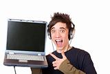 Male Teenager with earphones and laptop points enthusiastic at computer display