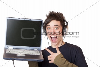 Male Teenager with earphones and laptop points enthusiastic at computer display