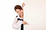 Young happy woman points with finger on blank billboard