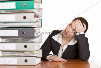 Frustrated business woman in office looks at unbelievable folder stack