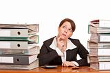 overworked contemplative business woman in office between folder stacks