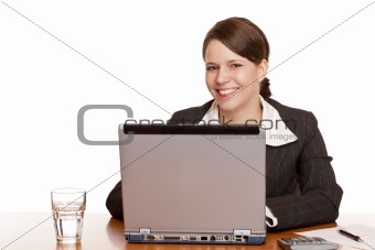 Young business woman sitting happy in office and works on computer