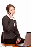 Young attractive business woman talks to client on the telephone