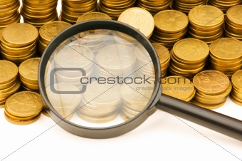 Stack of coins and magnifying glass on the white