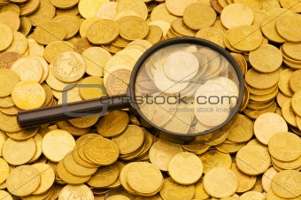 Magnifying glass and lots of gold coins