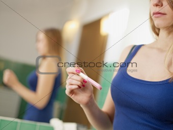 young woman with pregnancy test kit