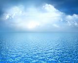 Blue ocean with white clouds on horizon