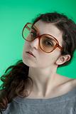 girl with big glasses on a green background 