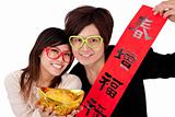 Chinese new year. Young couple holding gold ingot and red spring couplets
