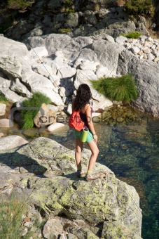 trekking woman on a rock watching river