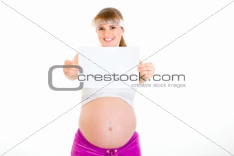 Smiling beautiful pregnant woman holding empty white  paper
